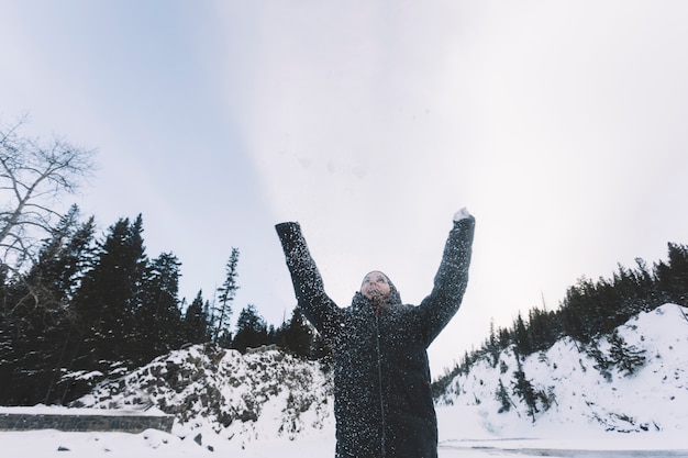 Person throwing snow on forest background