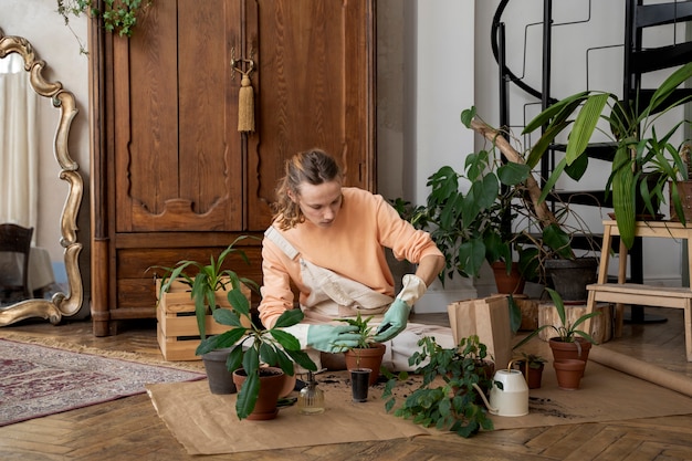 Free photo person transplanting plants in new pots