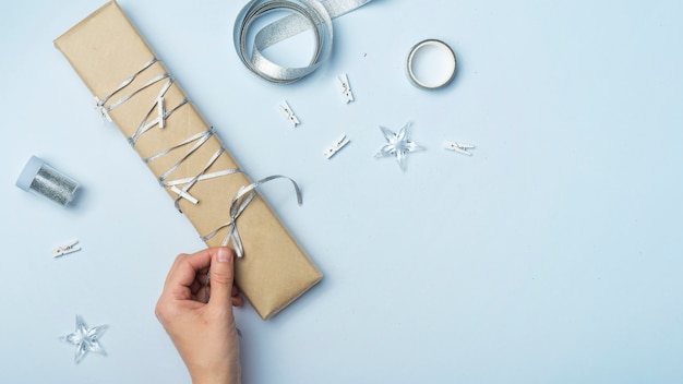 Free photo person tying bow on big gift box