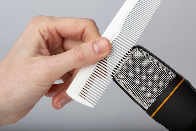 Free photo person using comb close to microphone for asmr