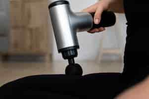 Free photo person using massage gun