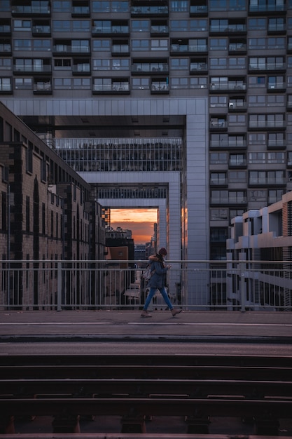 Free Photo person walking on bridge at sunset