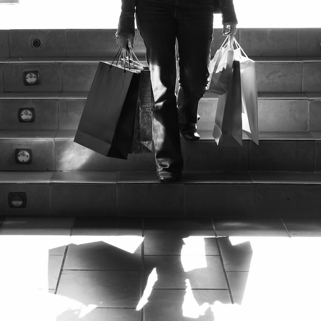 Person walking on stairs with shopping bags