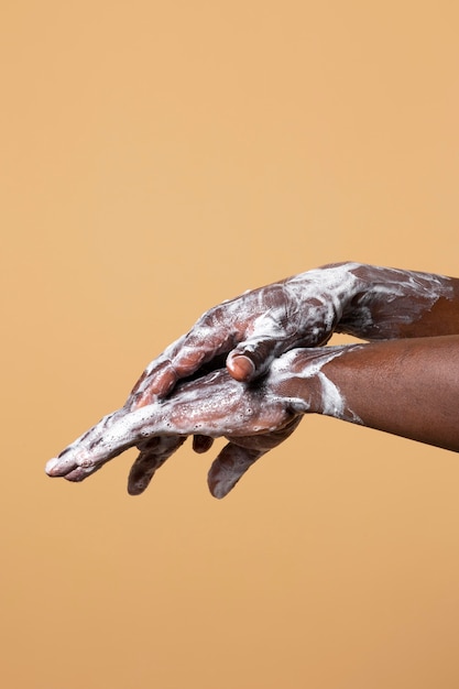 Free photo person washing hands with soap isolated on orange