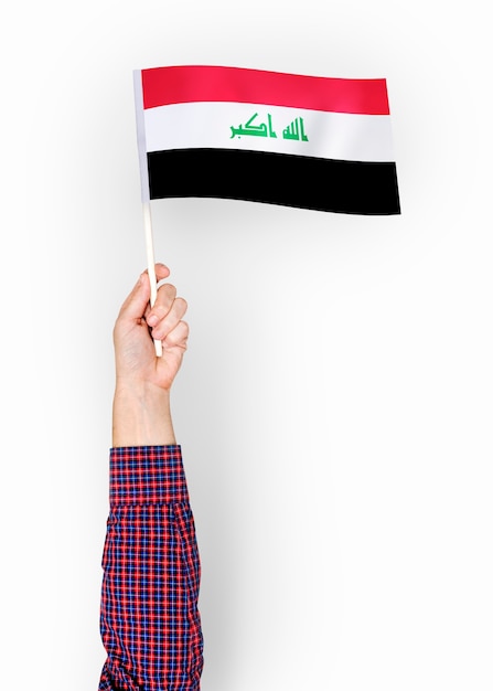 Free photo person waving the flag of republic of iraq