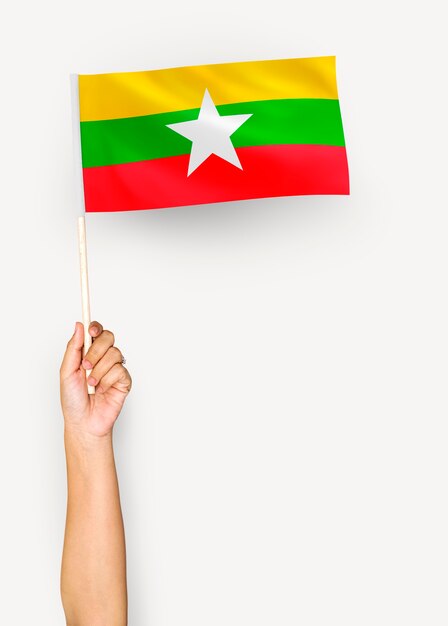 Person waving the flag of Republic of the Union of Myanmar