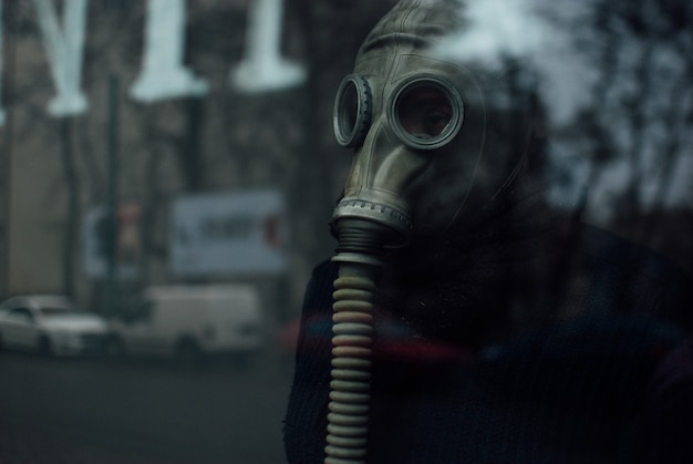 Person wearing a respirator standing behind the glass