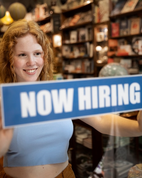 Person with hiring sign by the window