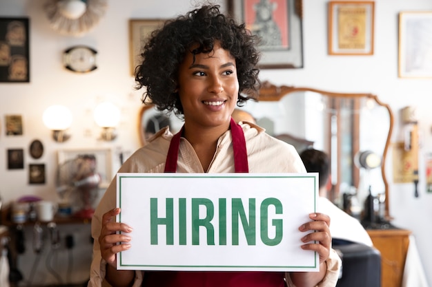 Person with hiring sign by the window