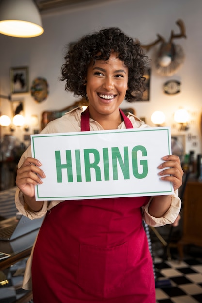 Person with hiring sign by the window