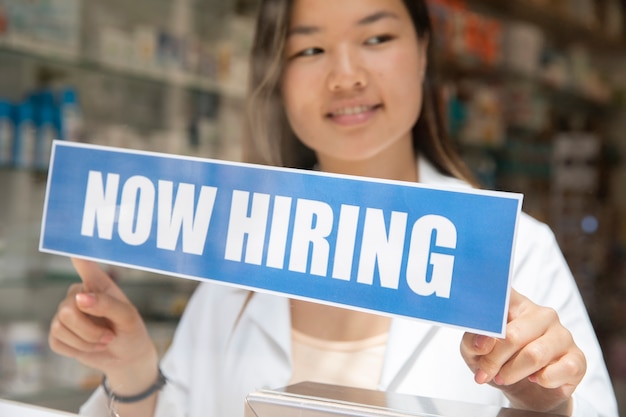 Person with hiring sign by the window