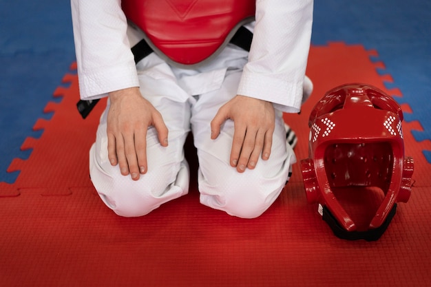 Free photo person with protective gear practicing taekwondo in a gymnasium