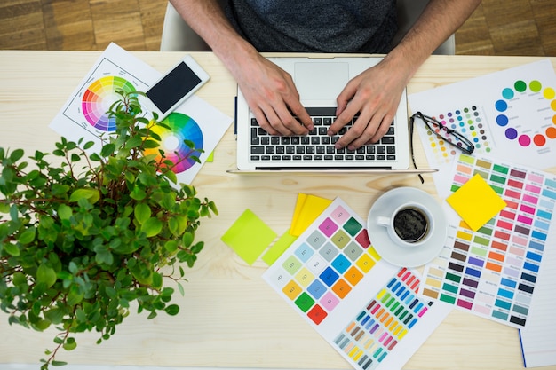 Person working with a laptop  and colors