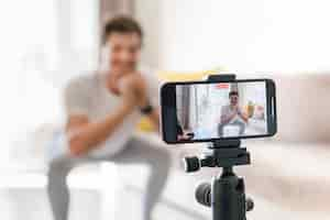 Free photo personal trainer recording exercises at home