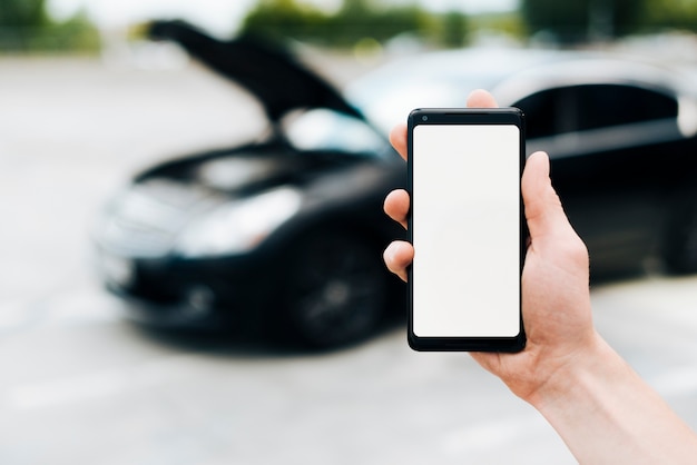 Free photo phone mock-up with car in background