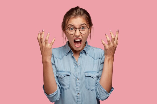 Photo of annoyed young woman gestures angrily