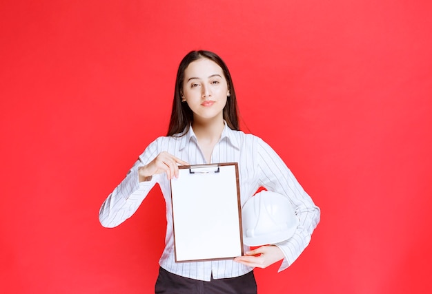 Free Photo photo of a beautiful business woman holding safety hat with folder.