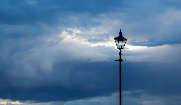 Free Photo photo of cloudy sky at dusk with classic streetlight