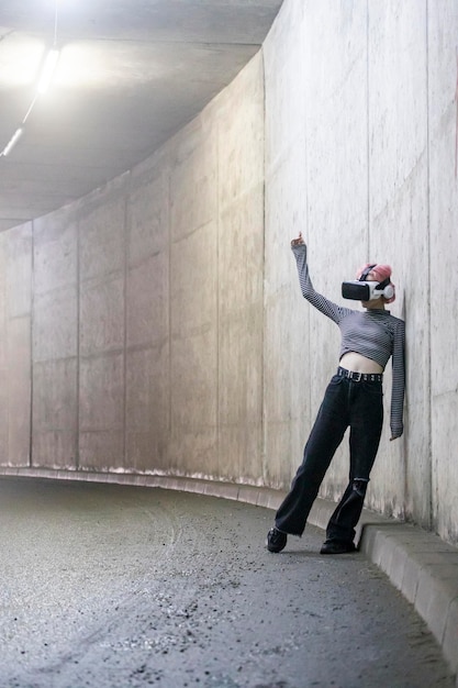 Free Photo photo of cyber girl wears vr set and leaning on wall at the tunnel