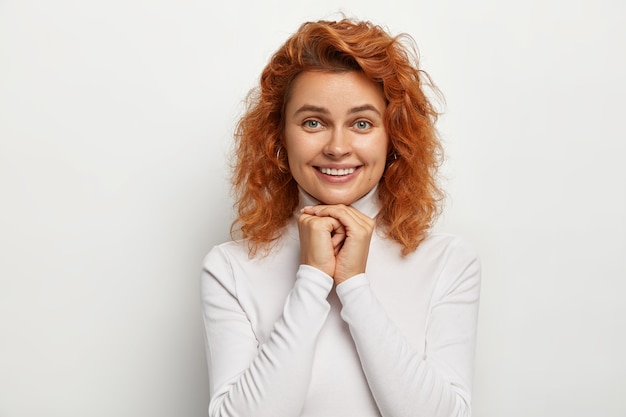 Photo of delighted smiling lady with ginger wavy hair