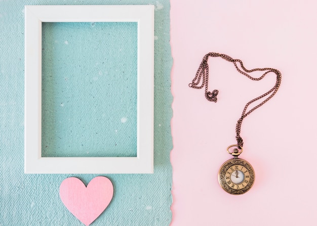 Free Photo photo frame and ornament heart on blue paper near old pocket watch