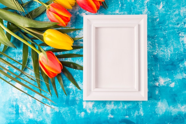 Free photo photo frame with flower bouquet on blue background