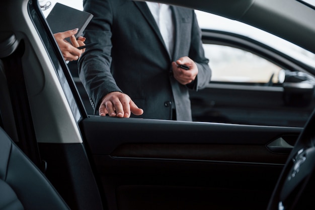 Free Photo photo from the inside of vehicle. female customer and modern stylish bearded businessman in the automobile saloon