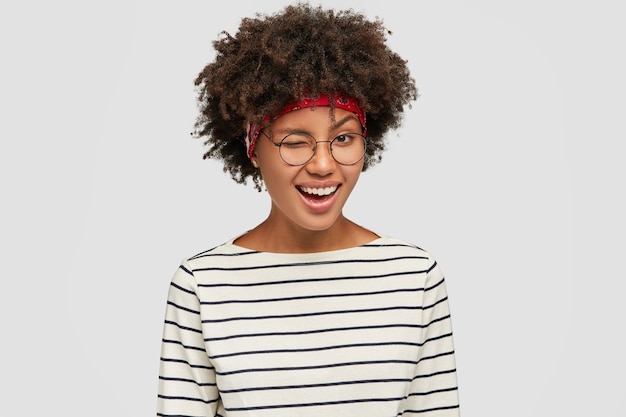 Free photo photo of good looking joyful girl flirts with stranger, blinks with eyes