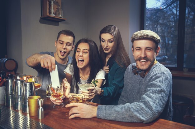 Photo of joyful friends in the bar or at pub communicating with each other