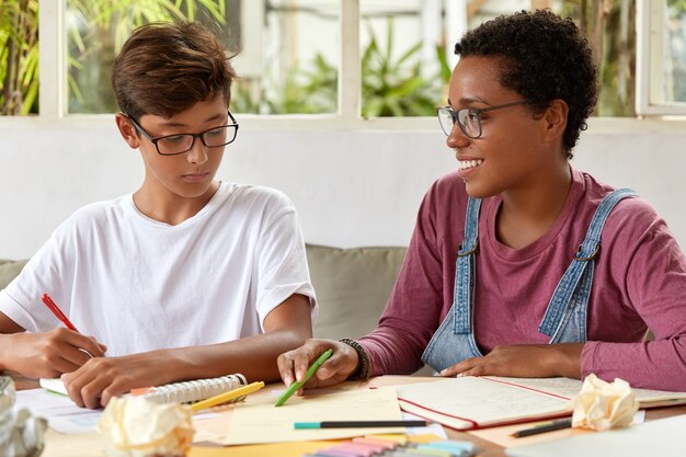 Photo of mixed race young women females sit together at table