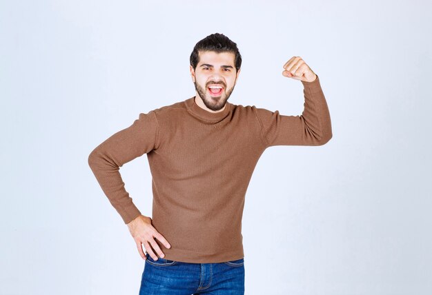 Photo of a young attractive model standing over white wall. High quality photo