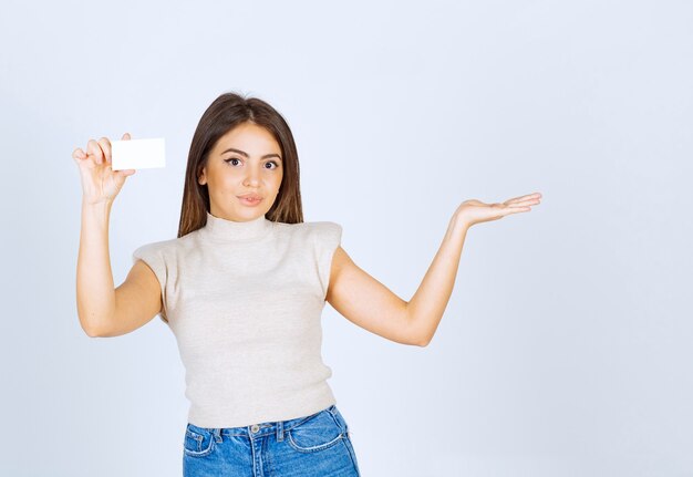 Photo of young beautiful woman model holding a card and showing a hand.