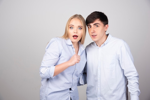 Photo of young couple standing and looking at camera