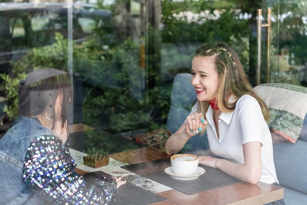 Photo of young girsl sitting at the restaurant and smiling