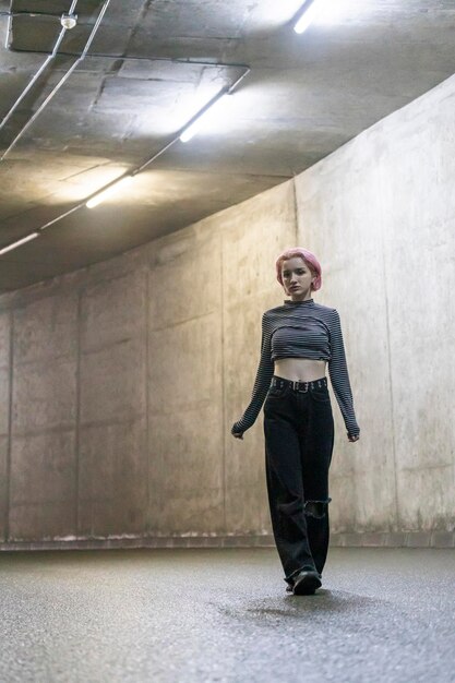 Photo of young lady walking at the tunnel