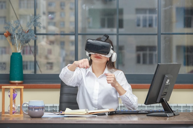 Free photo photo of young lady wearing vr glasses and squeeze her fists