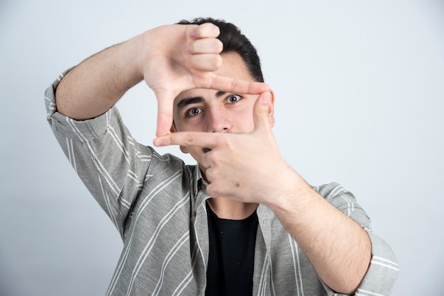 Free photo photo of young man in casual clothes posing to camera over white wall.