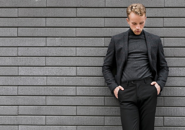 Free Photo photogenic young man leaning against the wall