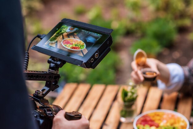 Photographer shooting a poke bowl on a professional camera in a park