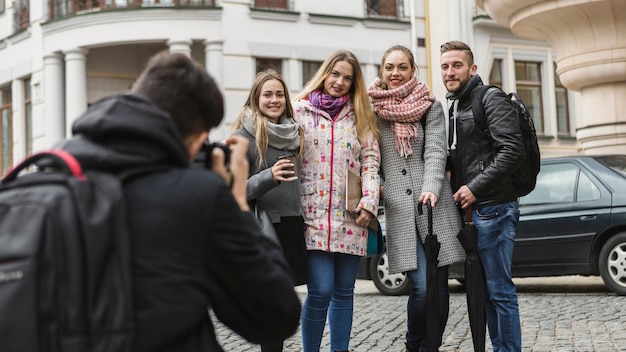 Free photo photographer taking shot of friends