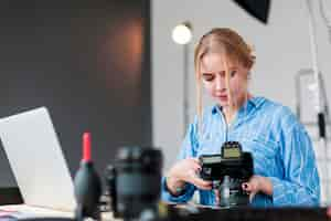 Free photo photographer woman and her lens standing at her desk