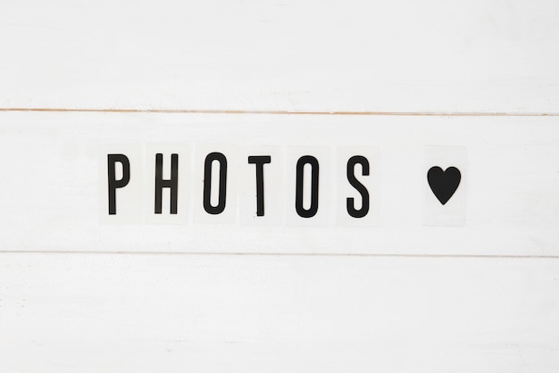 Free photo photos text and black heart shape on white wooden background