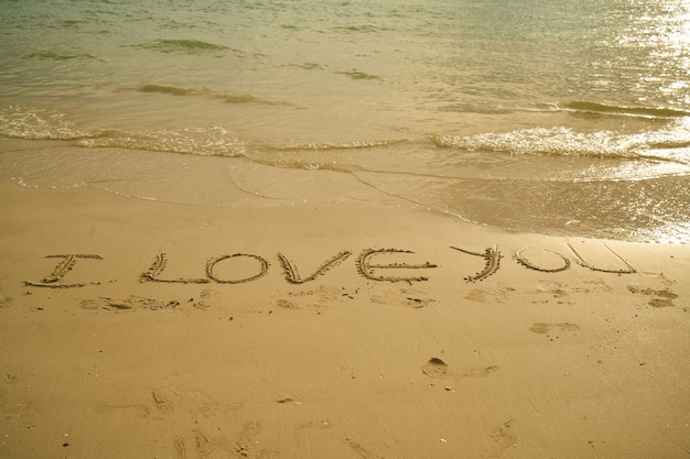 Phrase "i love you" written in the sand