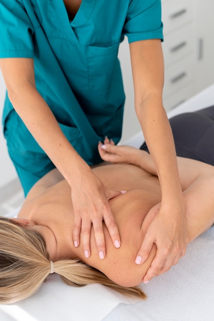 Free photo physiotherapist giving a massage to her patient at the clinic