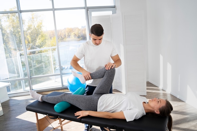 Physiotherapist helping patient full shot