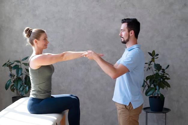 Physiotherapist helping woman medium shot