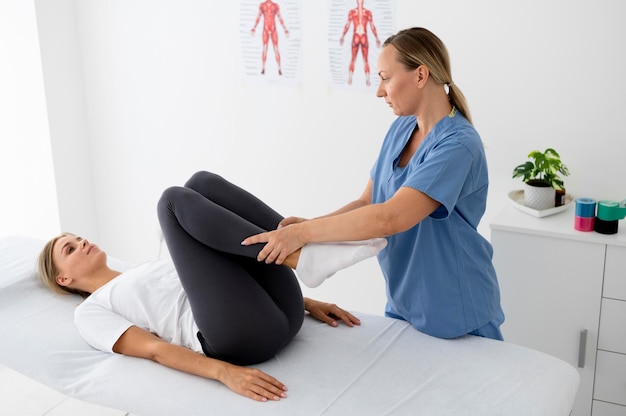 Physiotherapist helping a young female patient at her clinic