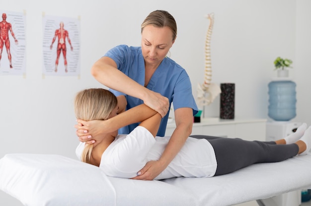 Free photo physiotherapist helping a young female patient