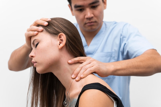 Physiotherapist massaging woman's neck