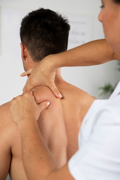 Physiotherapist performing therapeutic massage on male client